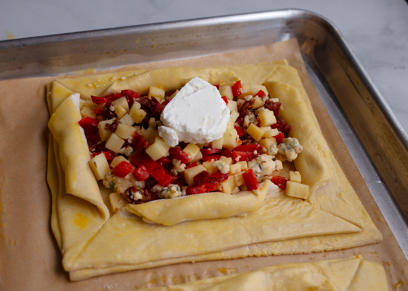 A slice of goat cheese on top of the cheese mixture before baking