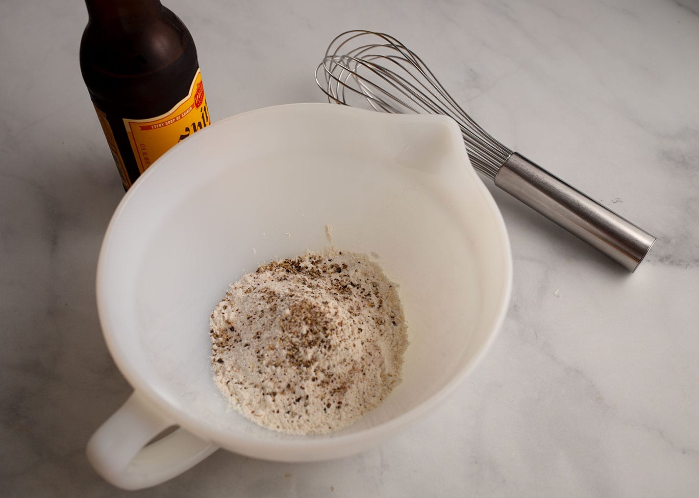 The frying batter is seasoned flour whisked with beer.