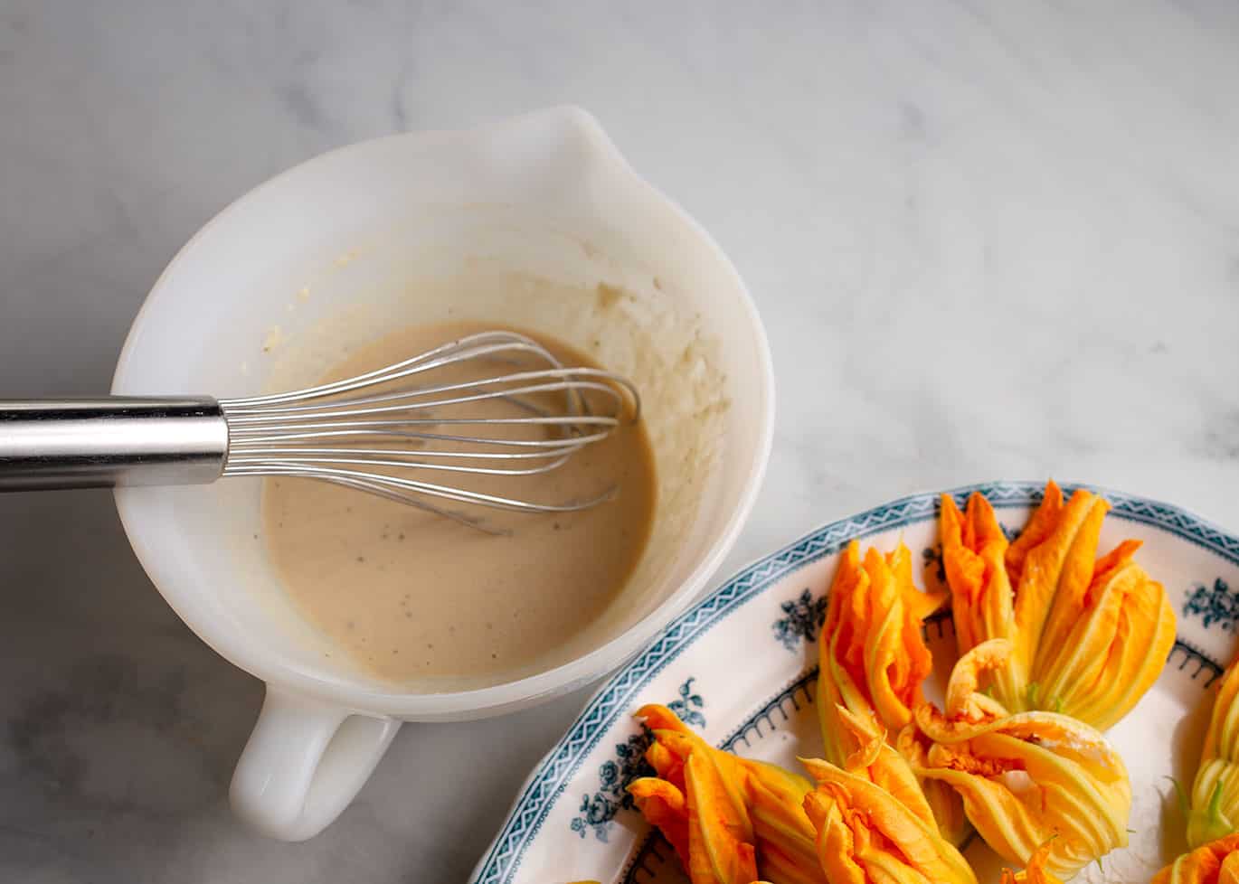 The thin beer batter in a mixing bowl.