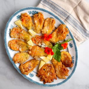 Lemon Ricotta Stuffed Zucchini Flowers on a blue and white platter