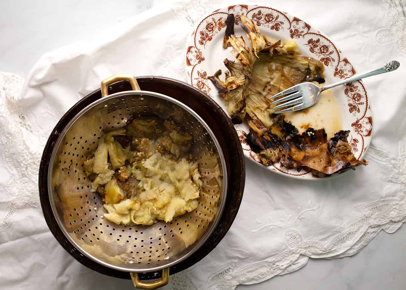 Scrape the insides of the grilled eggplant out and drain them in a colander to remove some of the moisture.